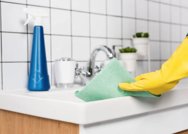 Person cleaning old mildew and mold from bathroom sink
